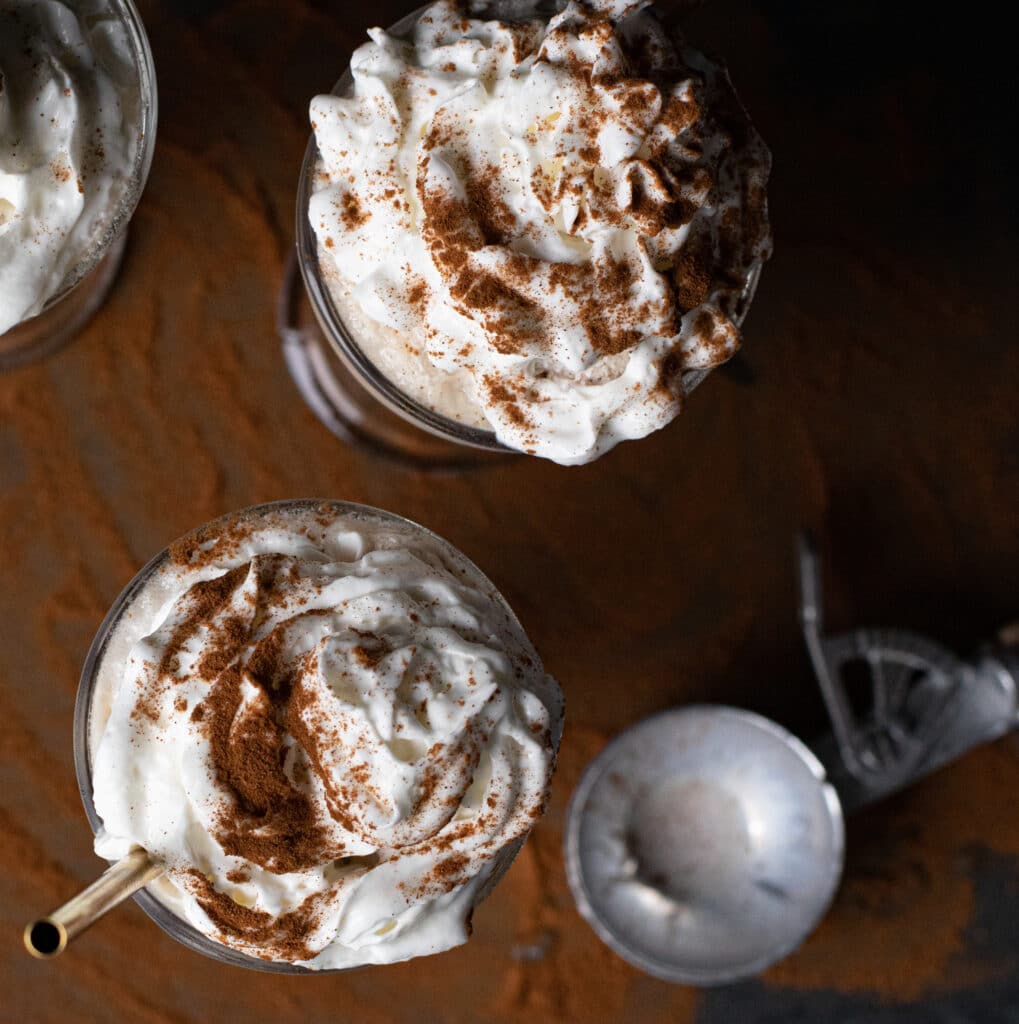 Top view of an apple cider float with whipped cream and cinnamon