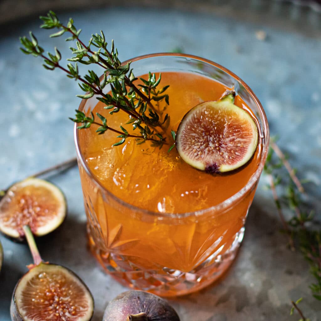 Fig Old Fashioned in a cocktail glass against a gray background