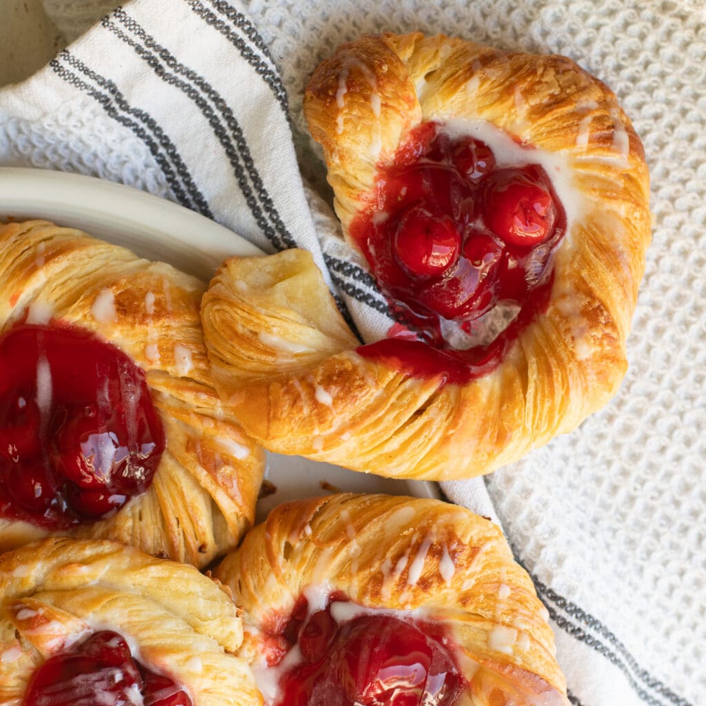 Close up of a cherry danish with the pastry pulled away from the center.