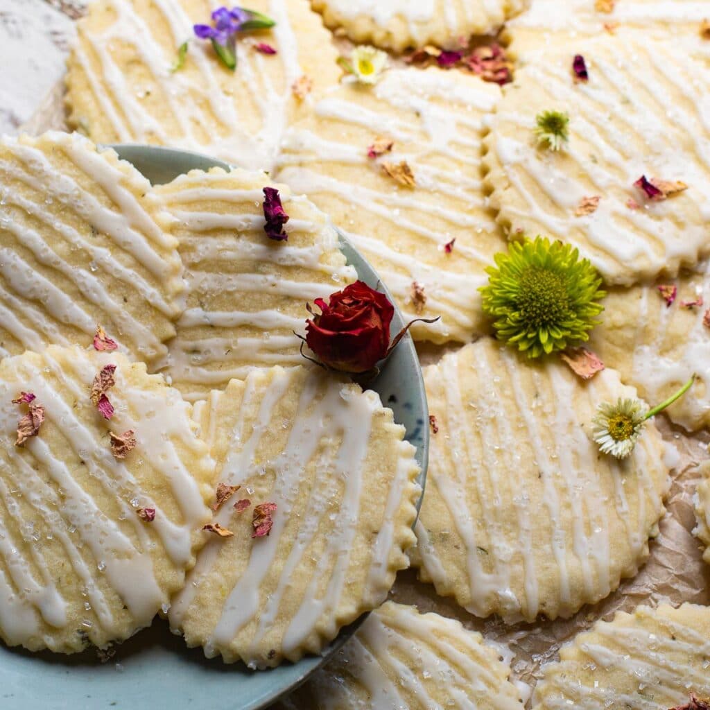 A plate of Lemon Rosemary Cookies garnished with fresh miniature flowers