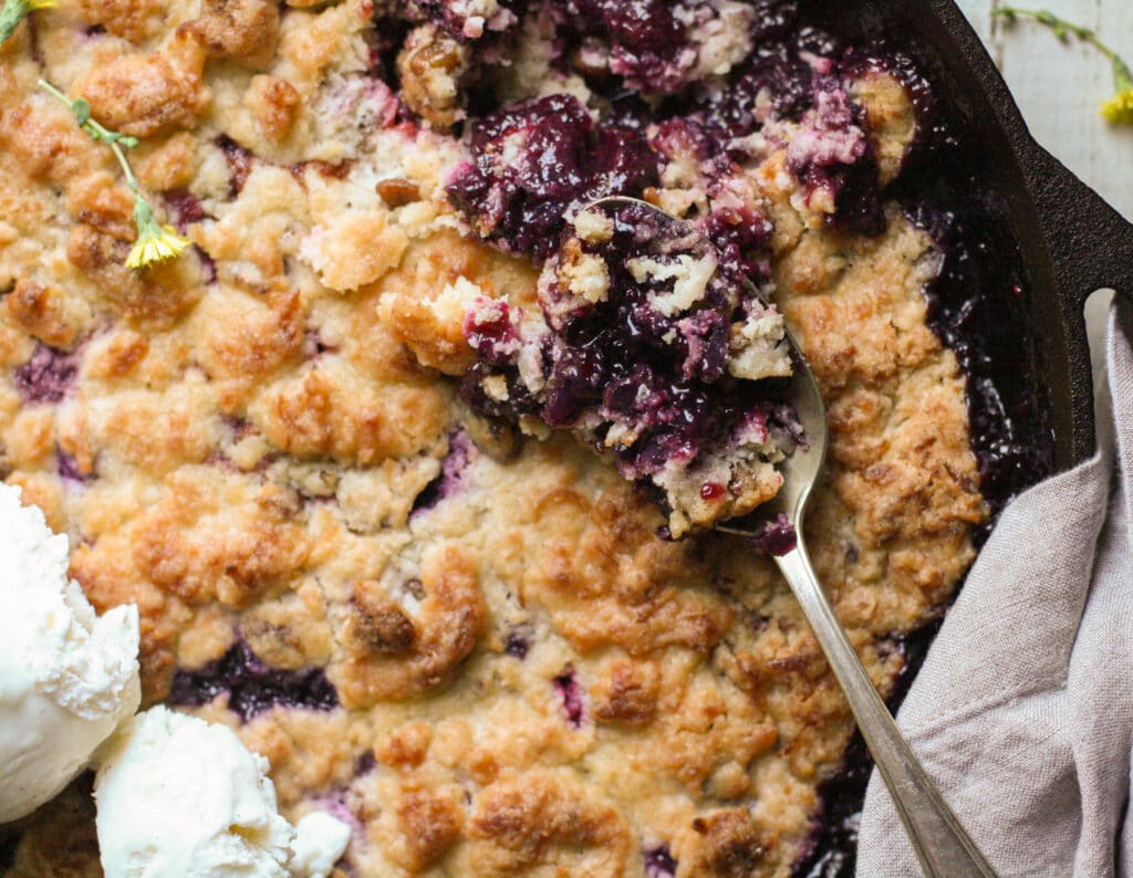 Spoonful of mixed berry cobbler in a cast iron skillet