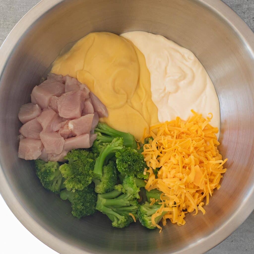 Ingredients for Cheesy Chicken and Broccoli Bake in a large stainless steel bowl