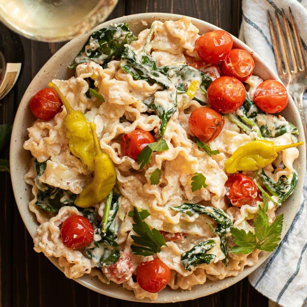 Pasta with feta cheese sauce, cherry tomatoes and spinach