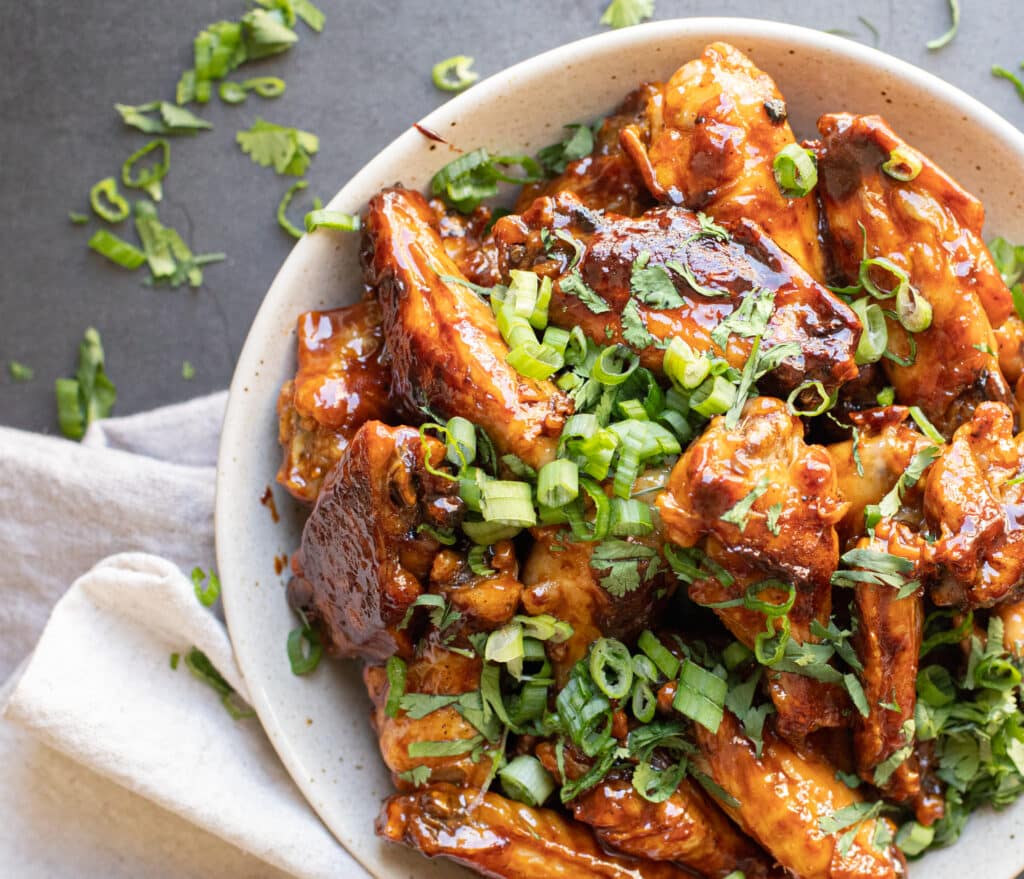 A bowl of garlic sticky soy chicken wings