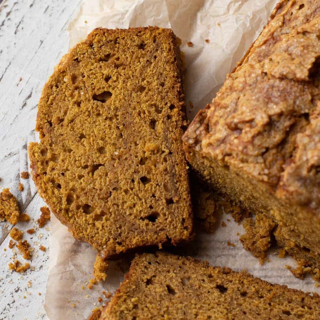 A slice of pumpkin bread on a white background