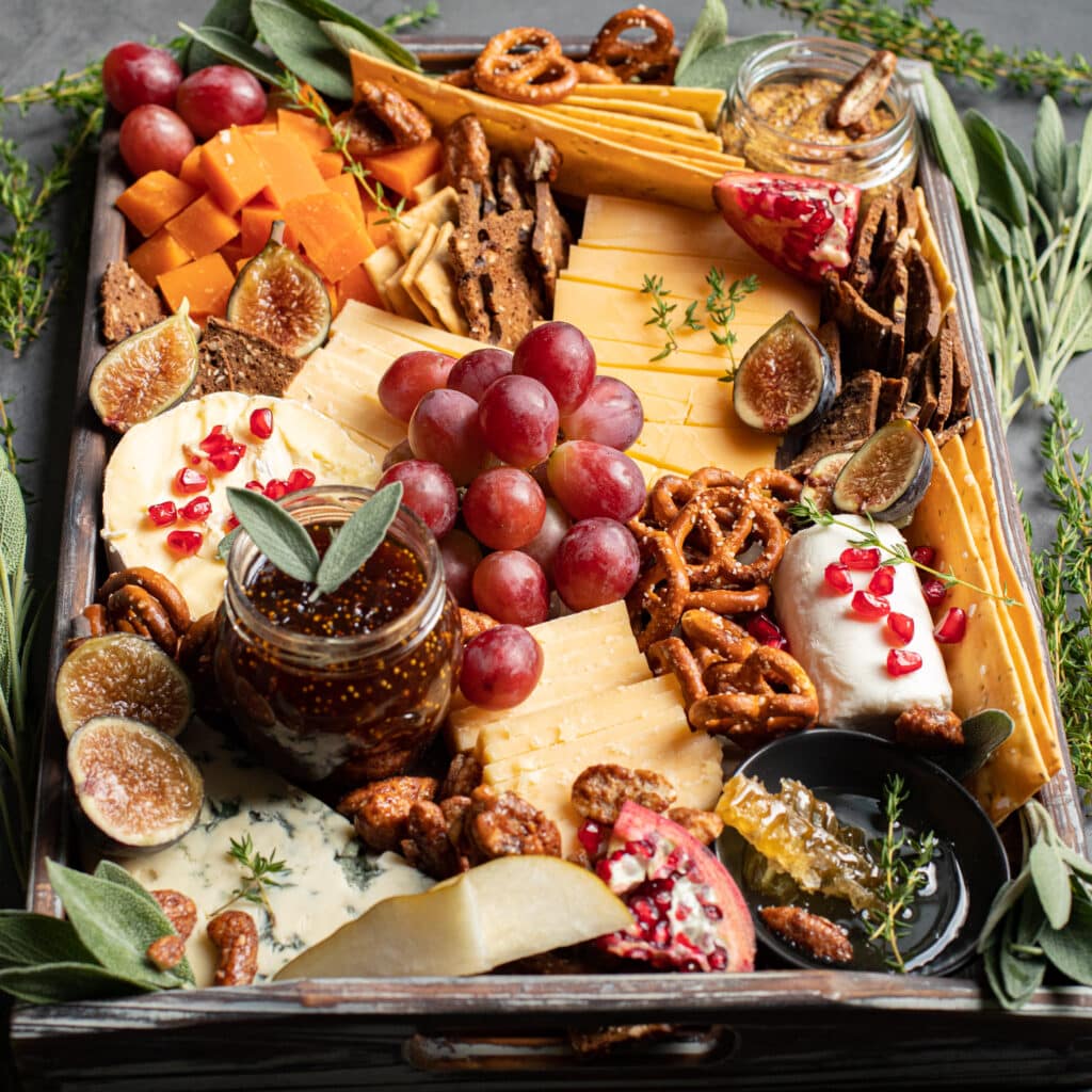 Fall Harvest Cheese Board with honey comb, fresh figs and pomegranates