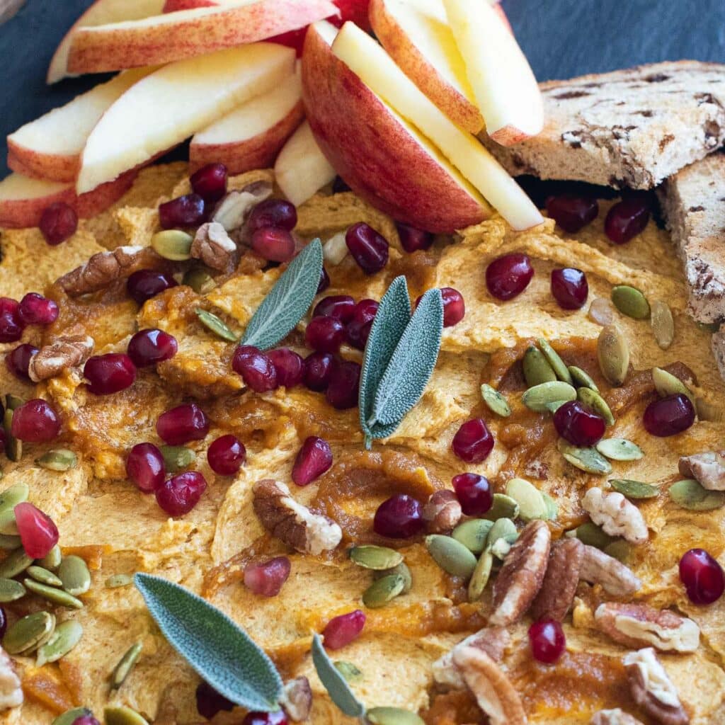 pumpkin butter garnished with sage leaves, pomegranate seeds and pecans