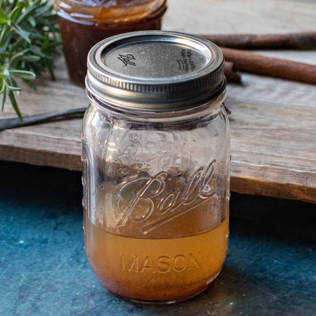 A mason jar filled with the ingredients for an apple butter vodka cocktail