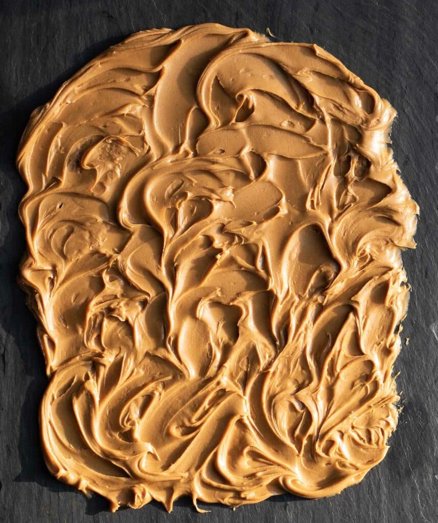 Peanut butter spread over a black slate serving board