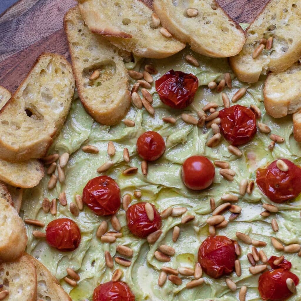 Pesto Butter Board with Roasted Tomatoes, Pine Nuts and Toasted Baguettes