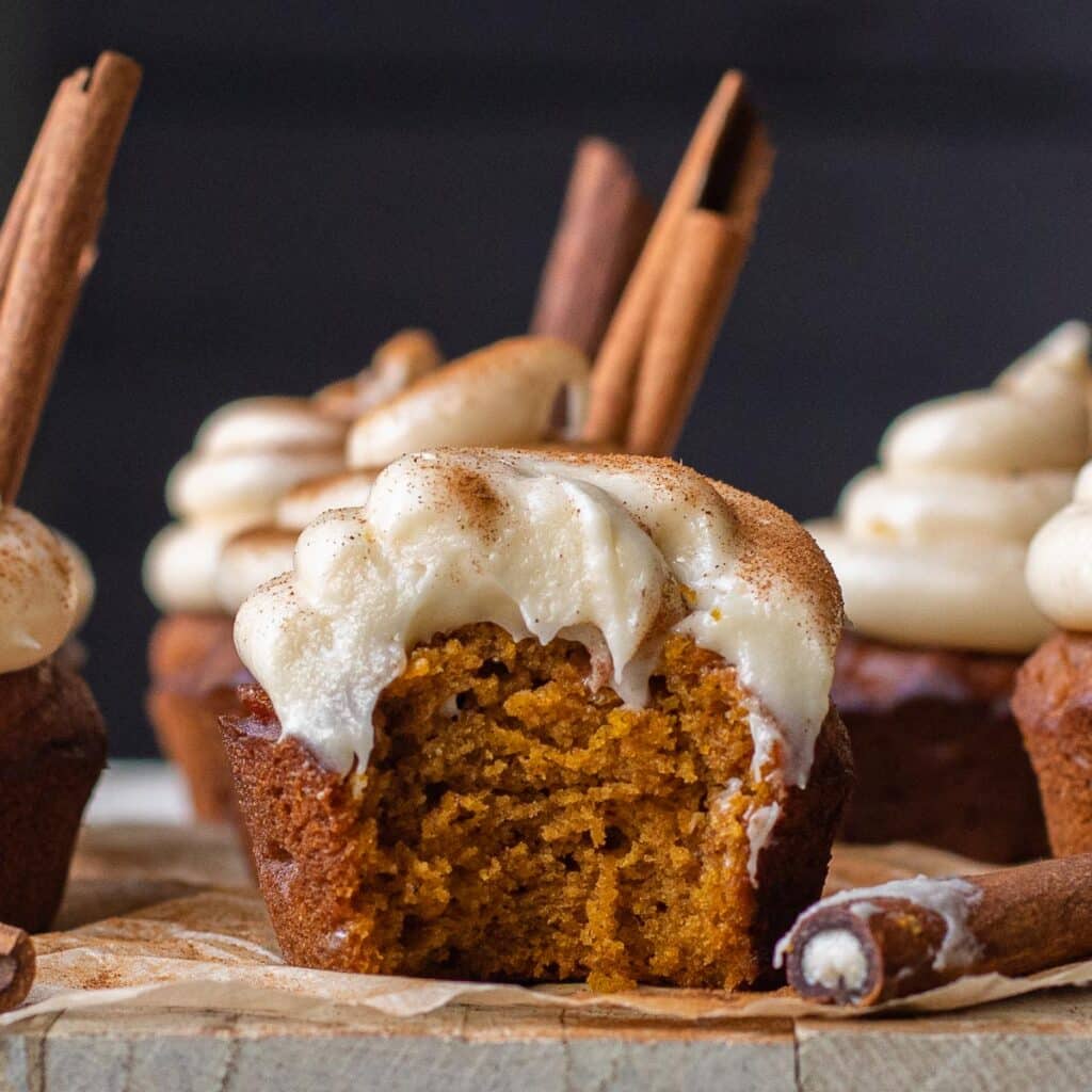 A pumpkin cupcake with a bite taken out of it