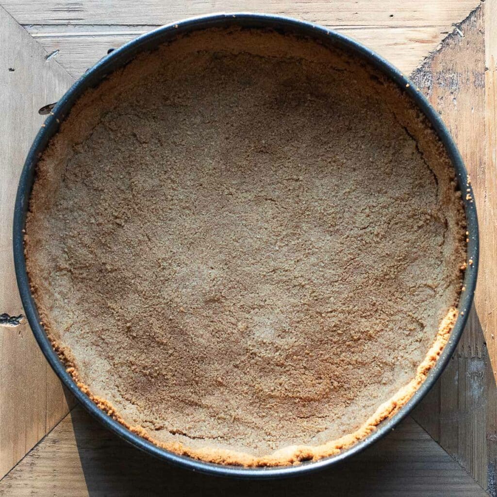 The graham cracker crust in a springform pan