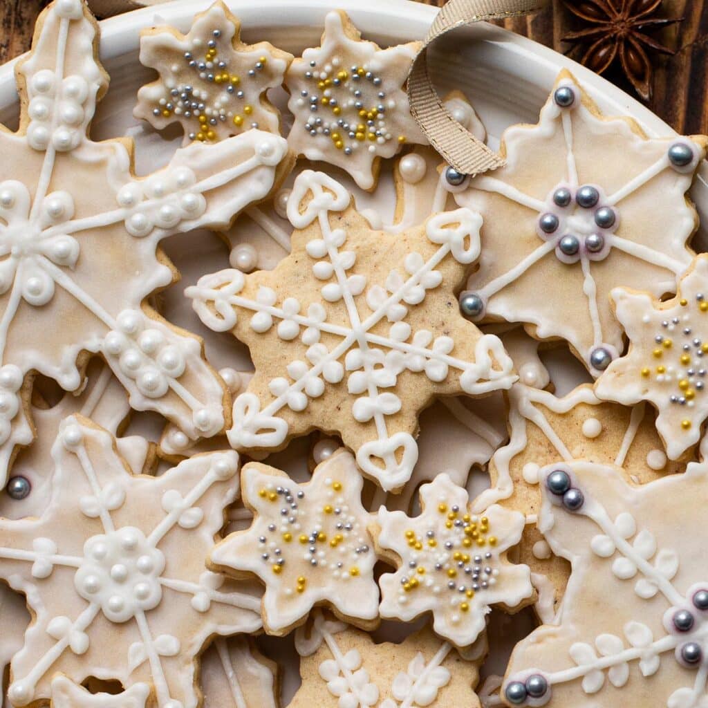 Eggnog cookies in snowflake shapes, decorated with gold and silver sprinkles