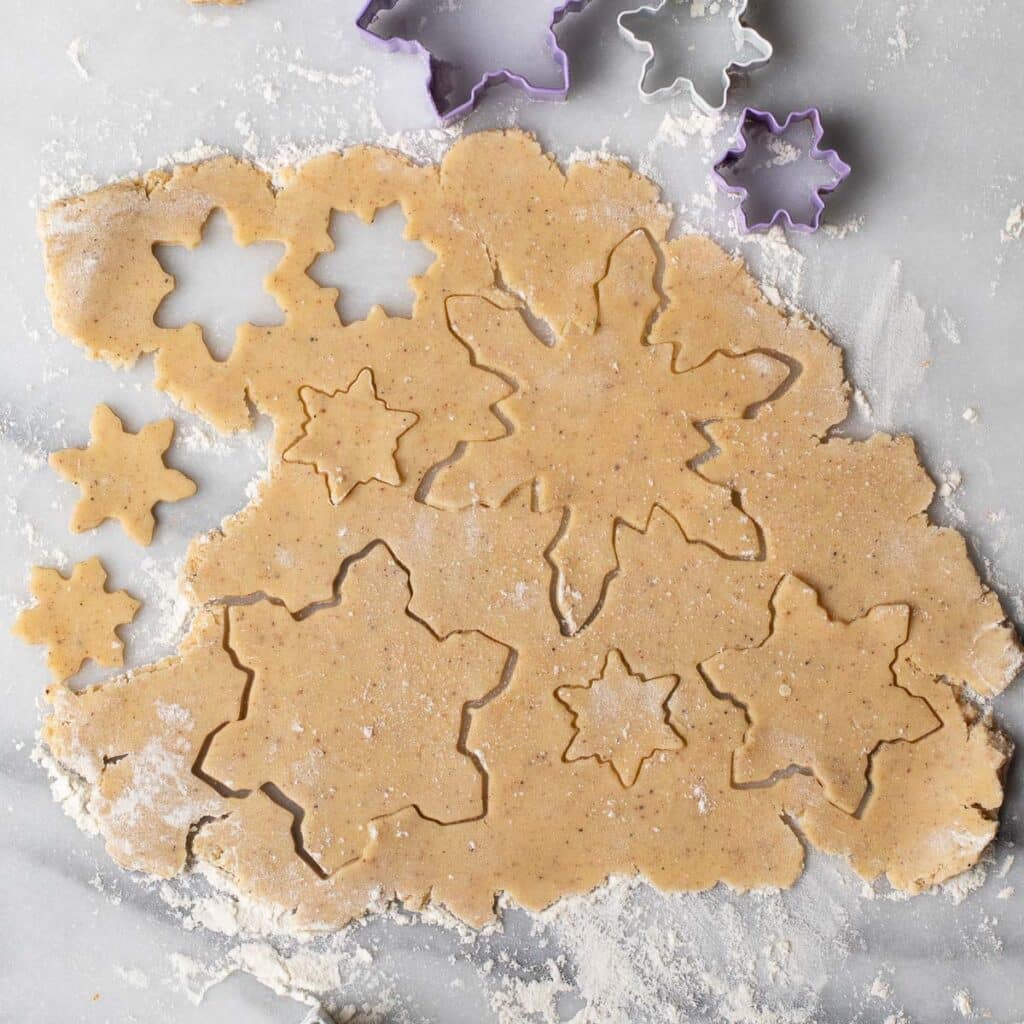 Cookie dough cut into snowflake shapes