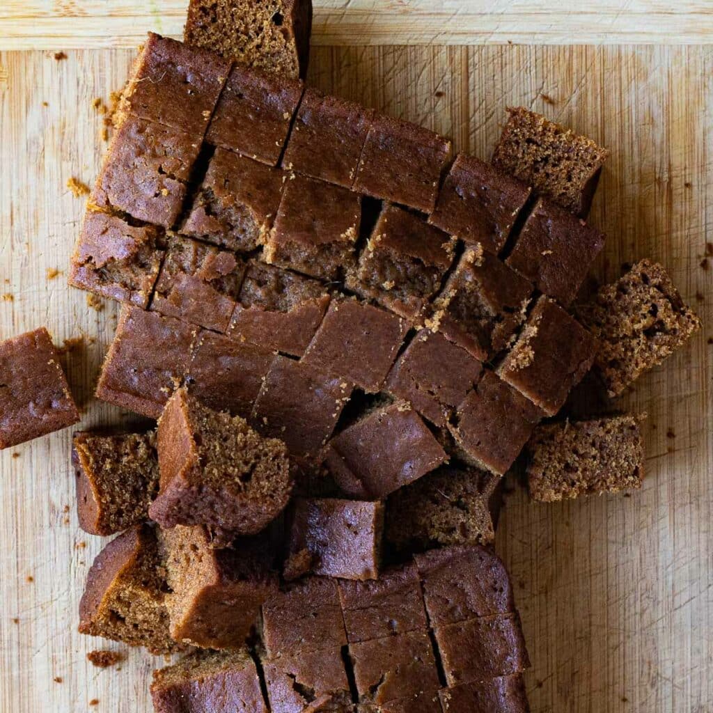 Gingerbread cake cut into cubes on a wooden cutting board