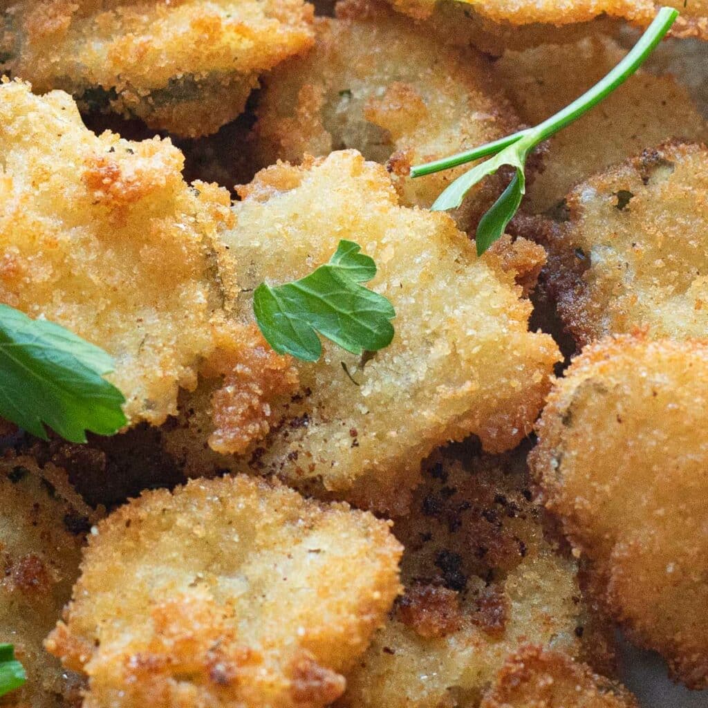 Close up photo of fried pickles garnished with fresh parsley