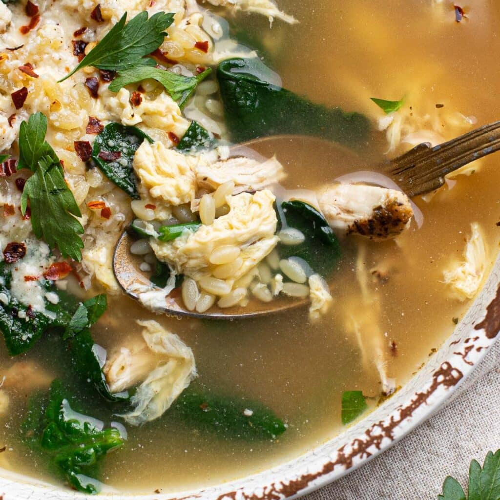 A spoonful of chicken, orzo and spinach soup