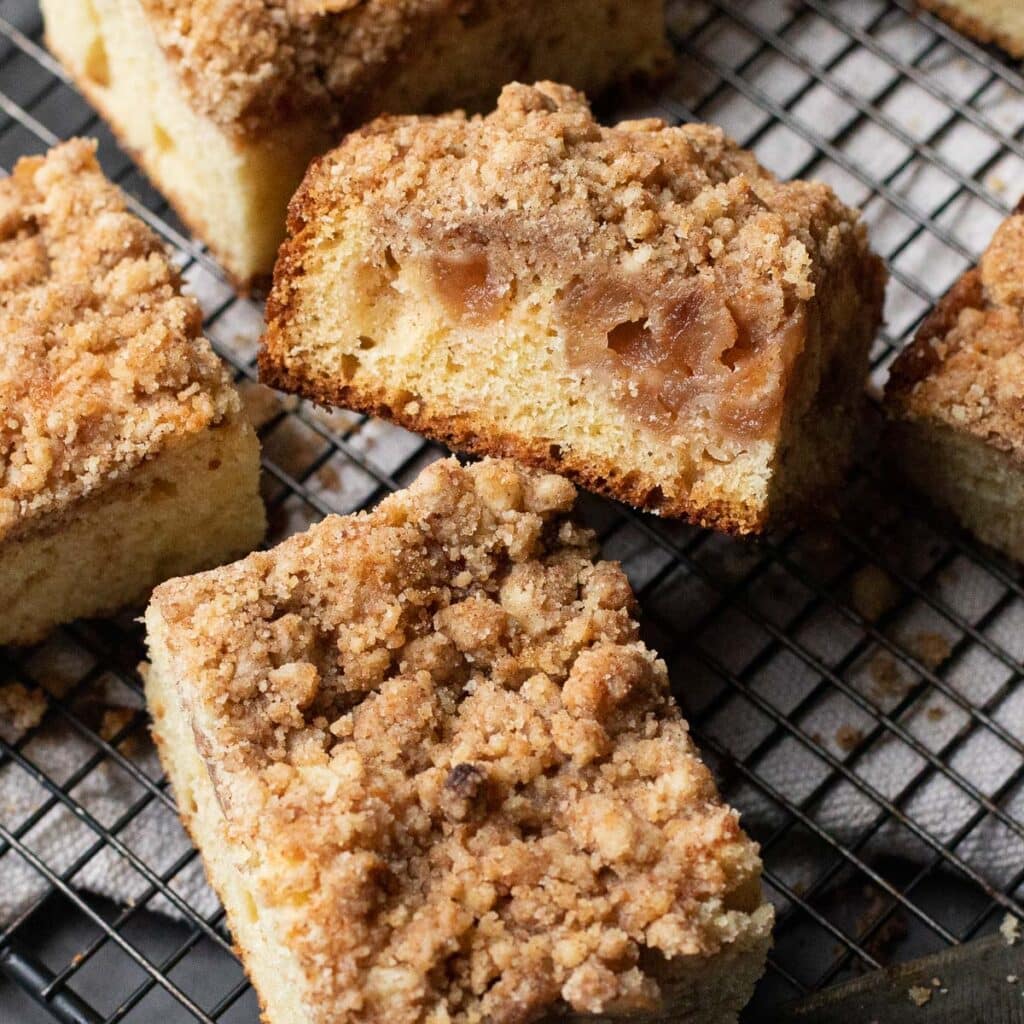 Two pieces of Apple Cinnamon Sour Cream Coffee Cake on a wire rack