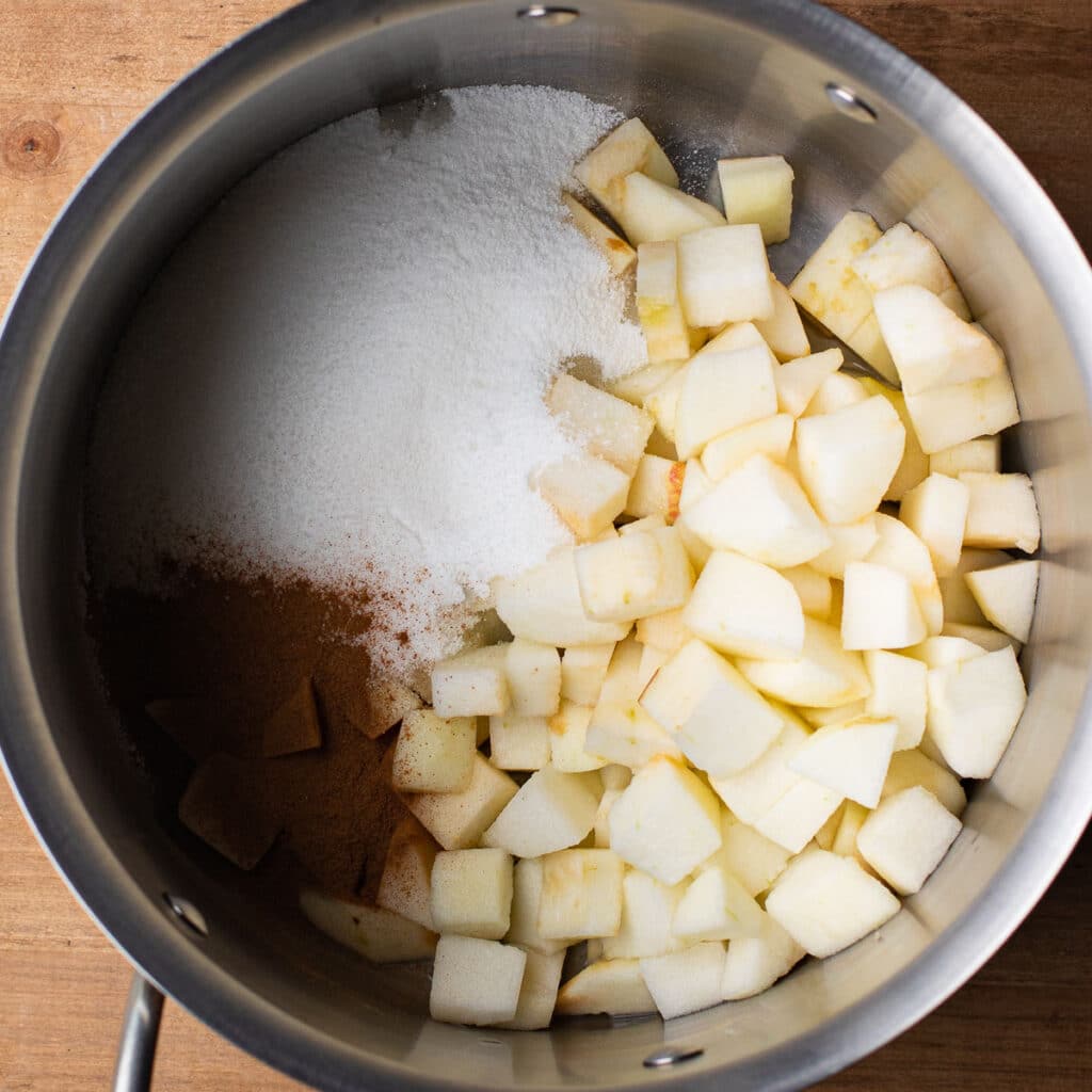 Cubes of apple, cinnamon and sugar in a saucepan
