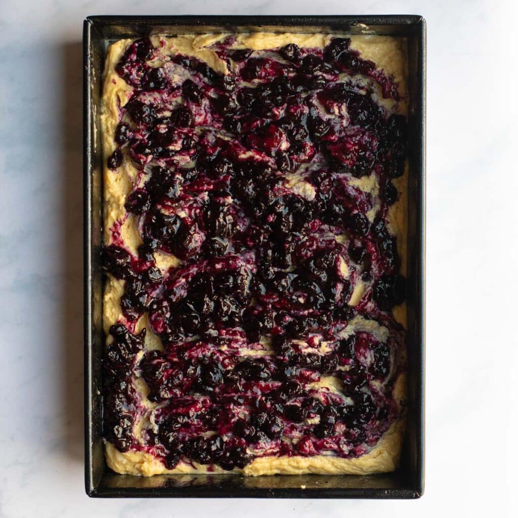 Homemade blueberry jam swirled through unbaked cake batter
