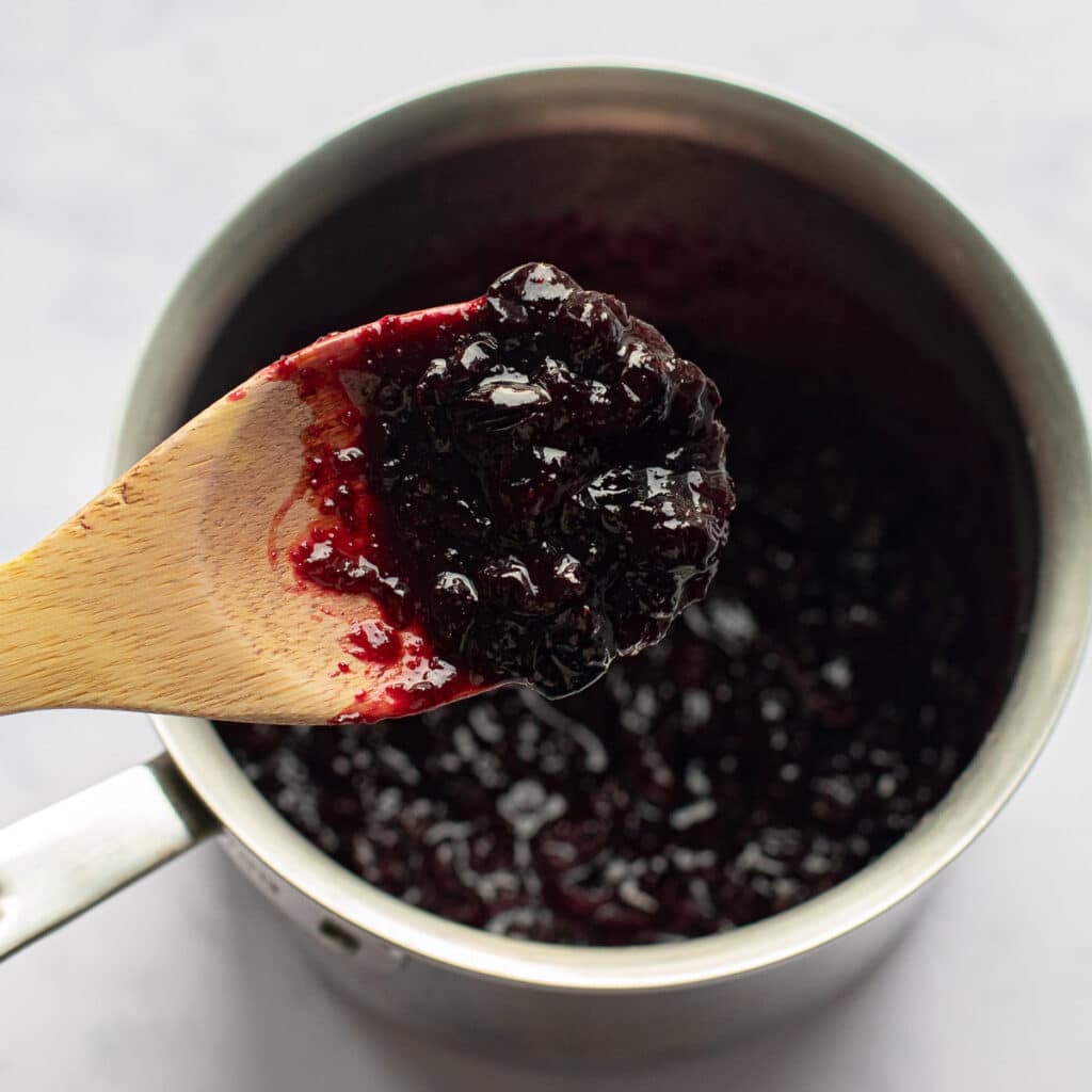 Homemade blueberry jam on a wooden spoon