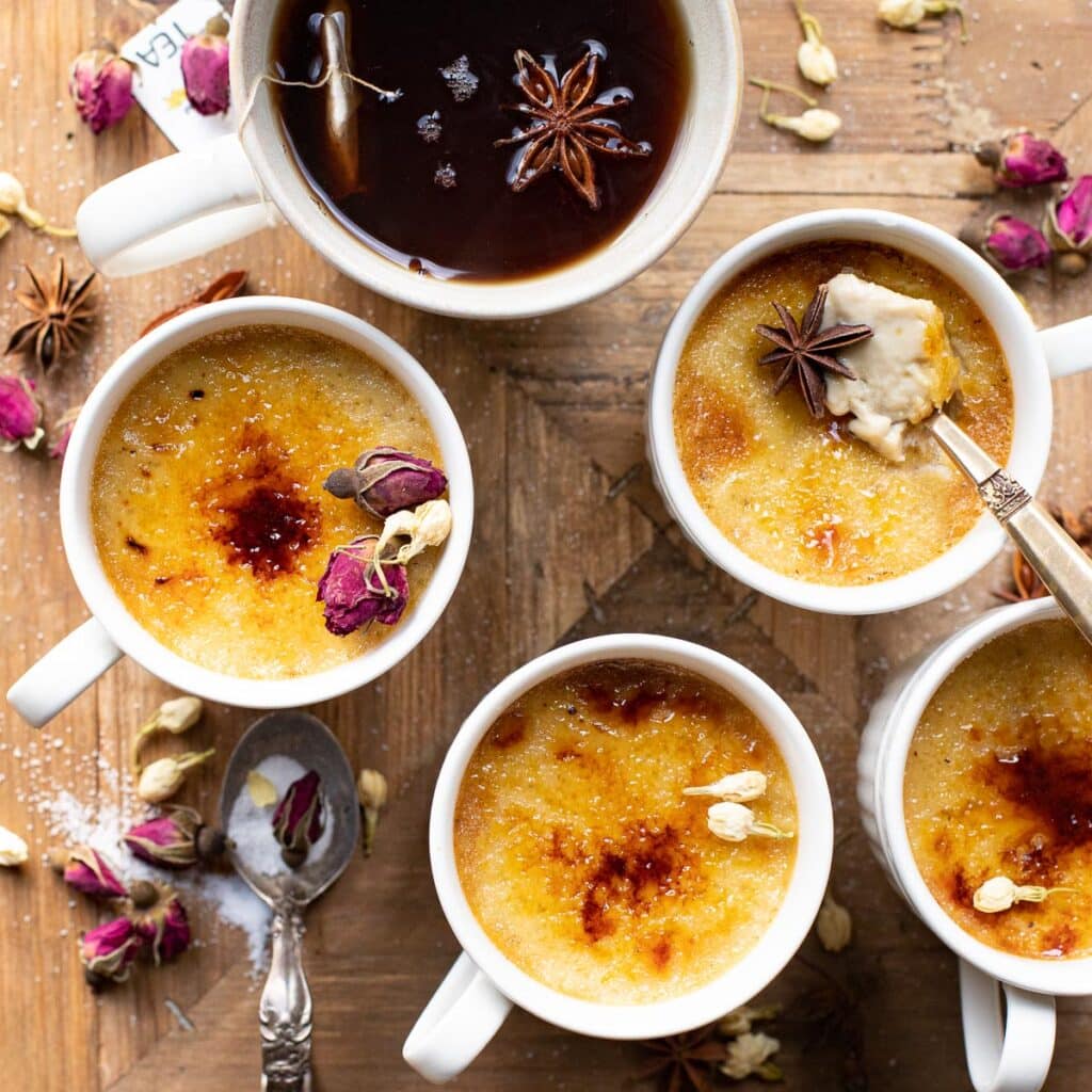chai spice creme brulee in white tea cups on a wooden board
