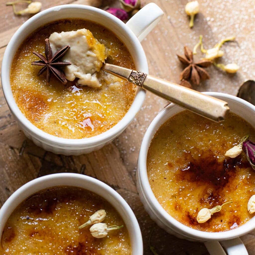 chai spice creme brulee in white tea cups with a gold spoon