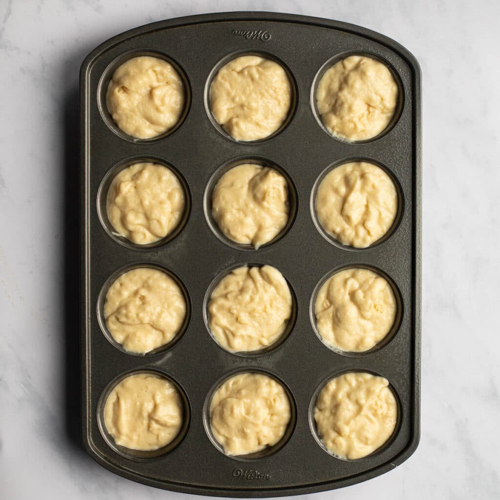A 12-cup cupcake pan filled with batter