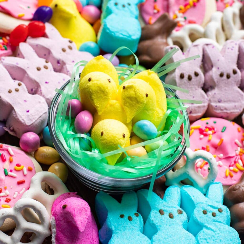 Marshmallow Peeps in a birds nest with pastel colored candies
