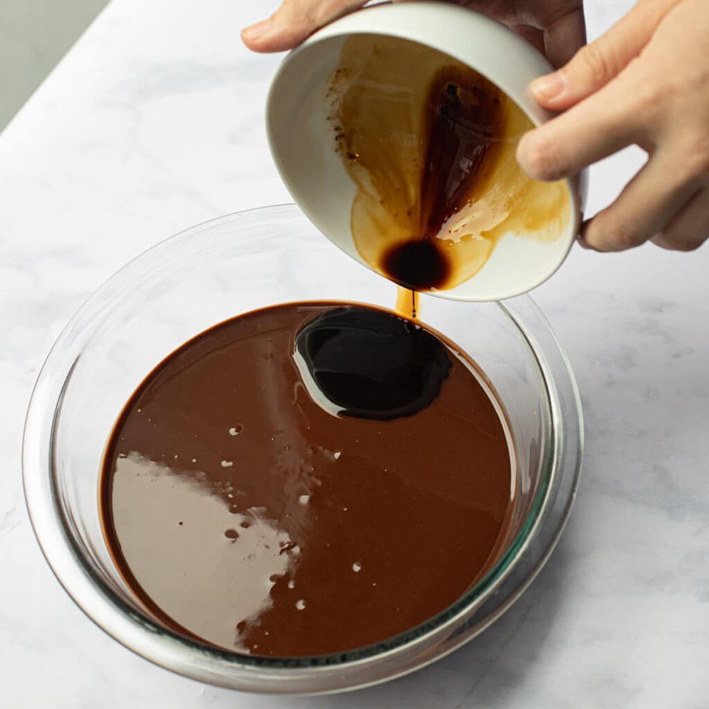 espresso being poured into a bowl of melted chocolate