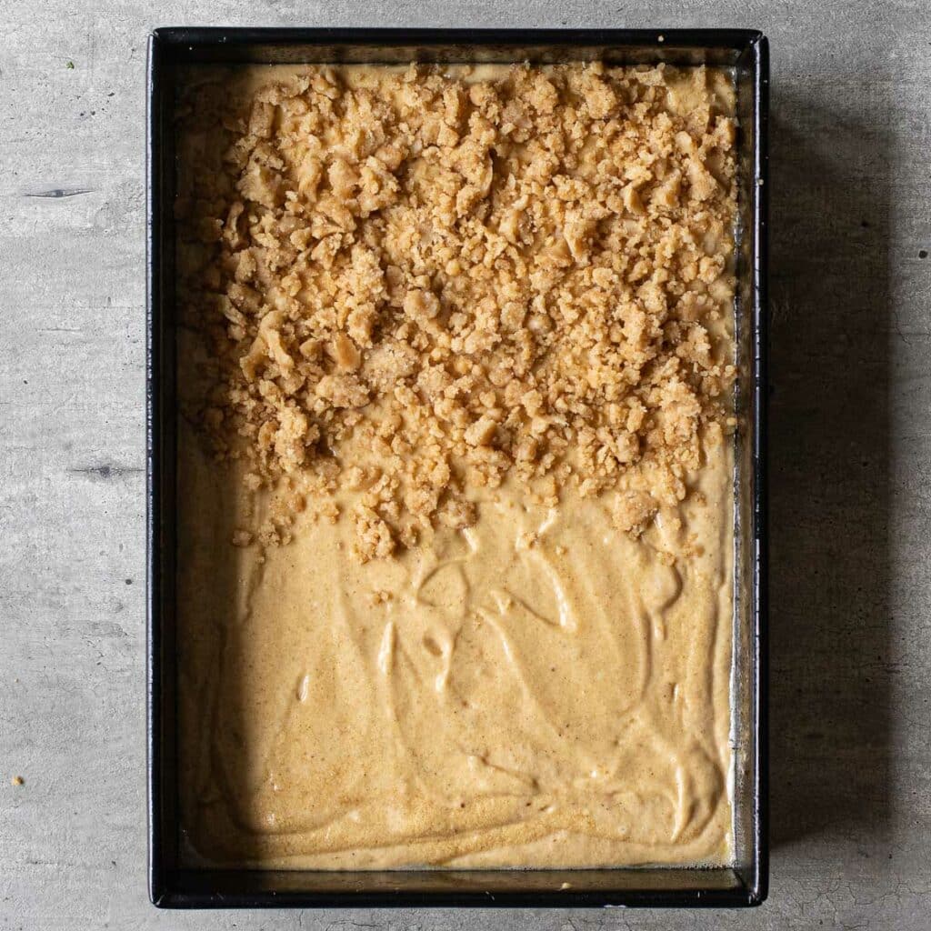 cake batter partially topped with streusel in a rectangular pan