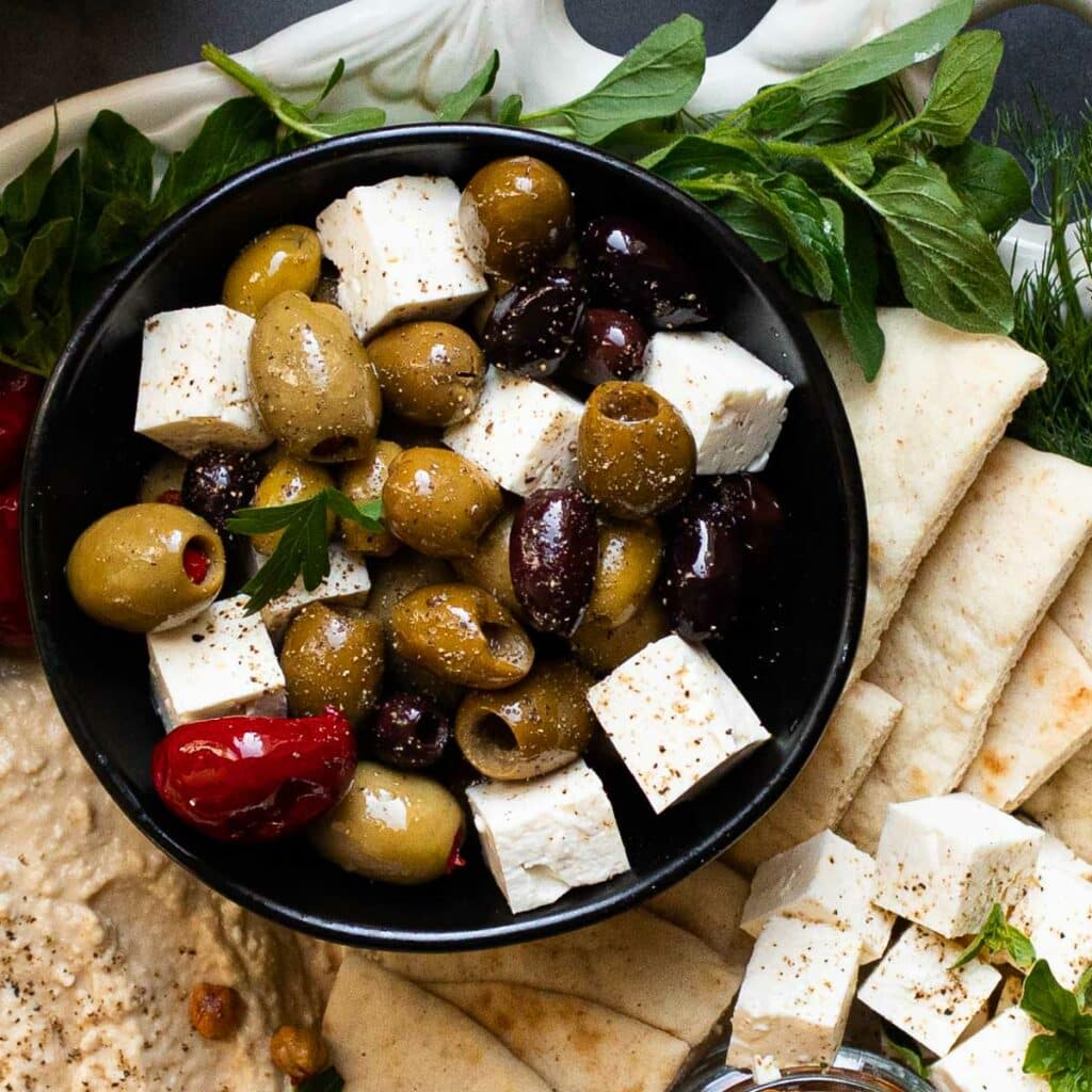 Greek olives and cubed feta cheese in a black bowl