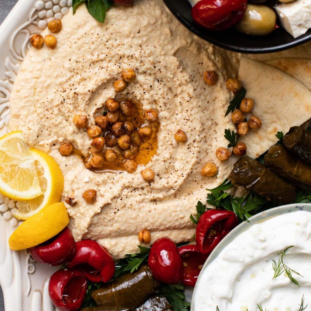 hummus topped with crispy chickpeas and lemon wedges