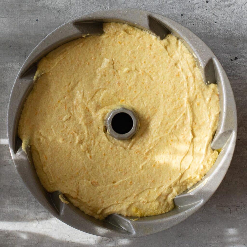 Orange butter cake batter in a bundt pan before it is baked