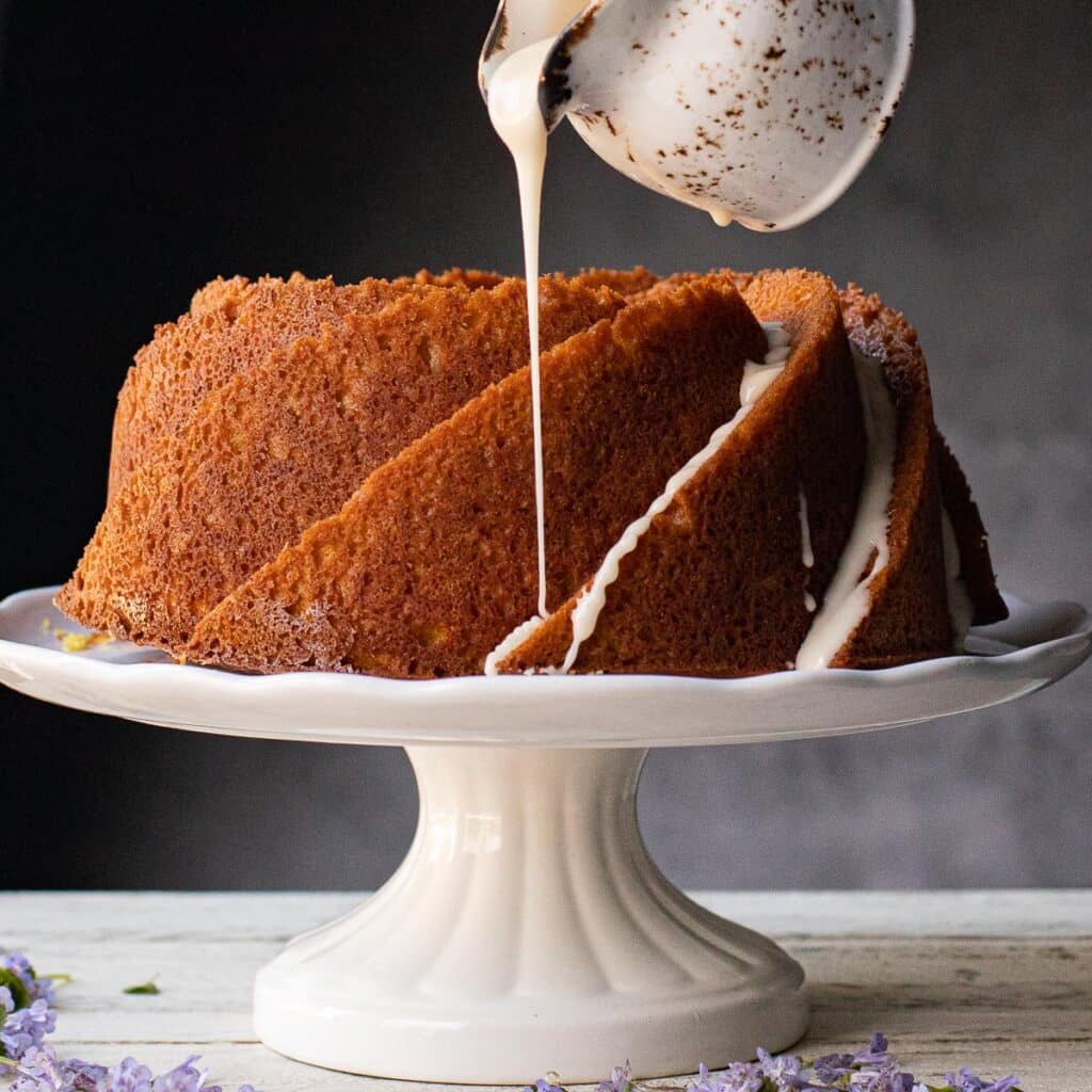 Vanilla glaze being poured over a bundt cake