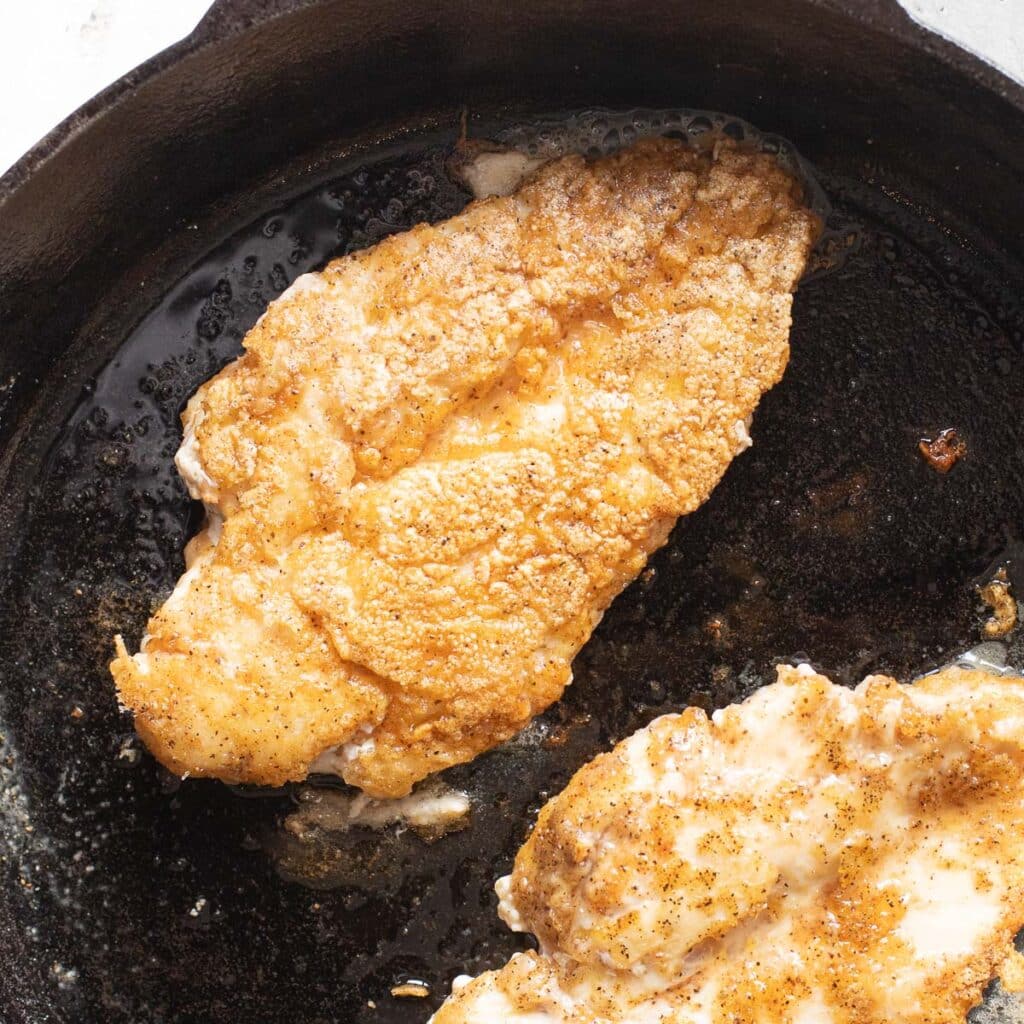 seared chicken breasts in a cast iron skillet
