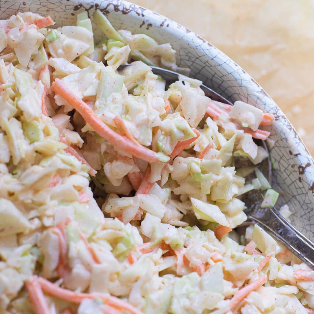 a large serving spoon holding southern coleslaw