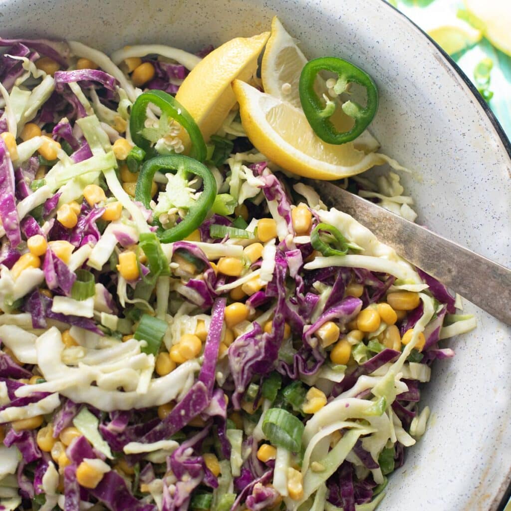 southwestern coleslaw in a bowl with a silver serving spoon