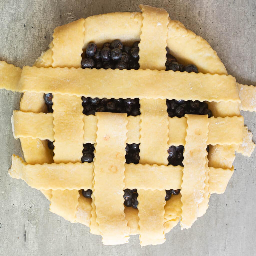 lattice pie crust on a blueberry pie before it is baked