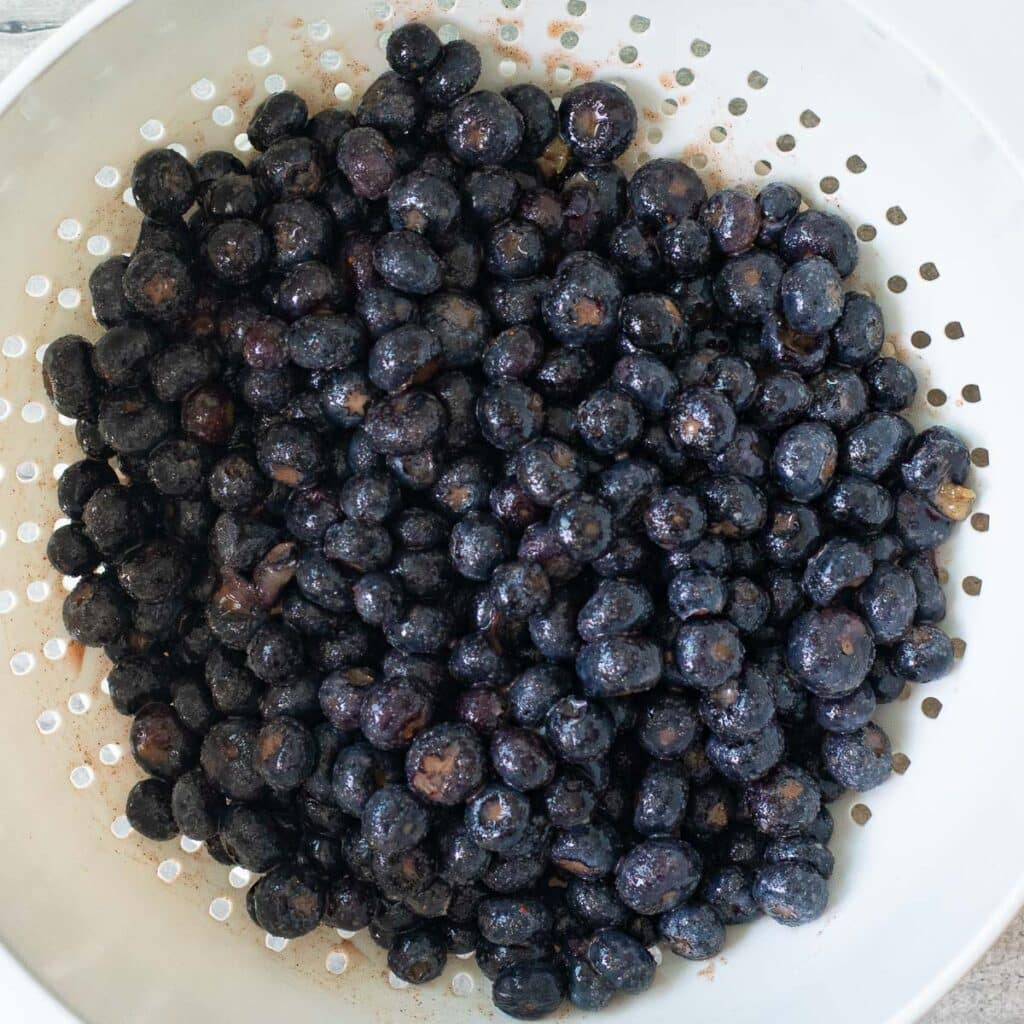 blueberries draining in a white colander
