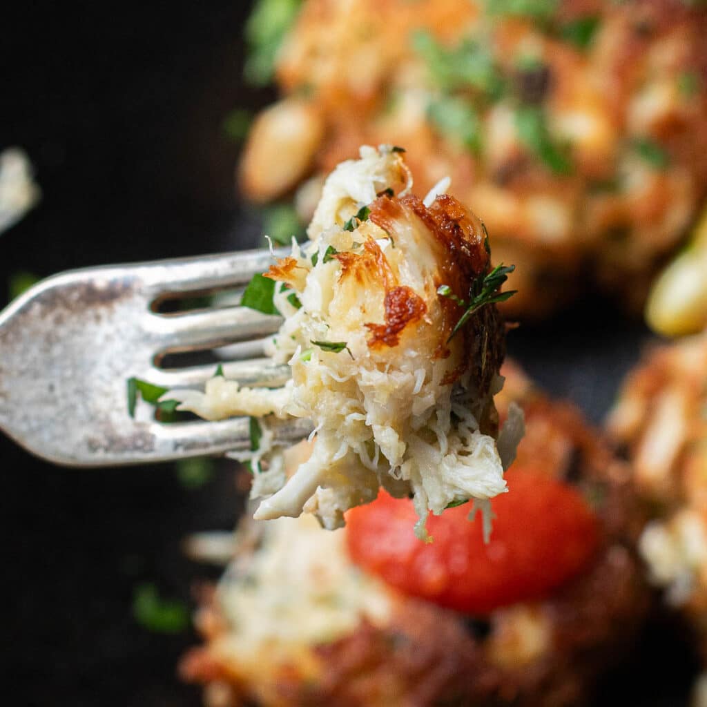 a fork holding a bite of crab cake