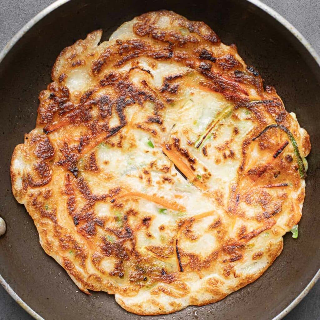 A Korean vegetable pancake after it is flipped
