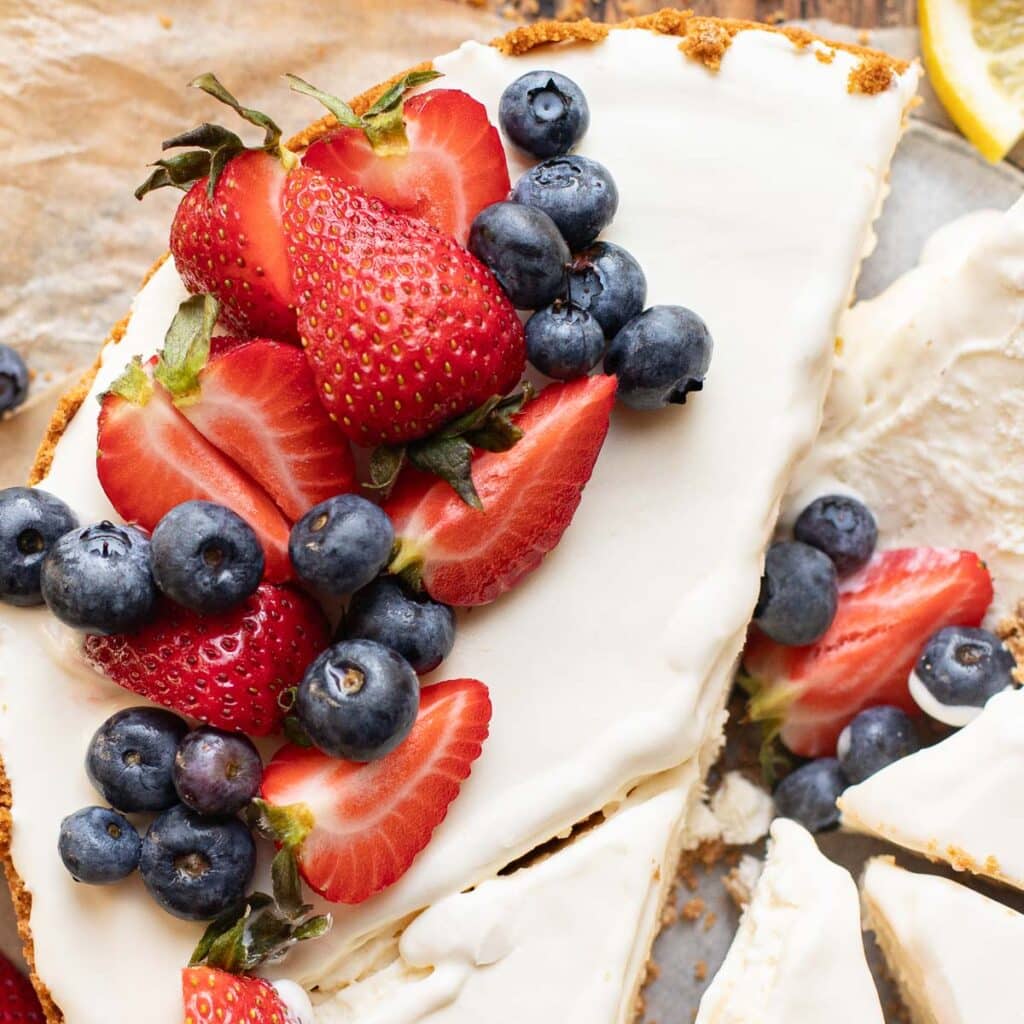 3 ingredient lemon ice box pie topped with strawberries and blueberries