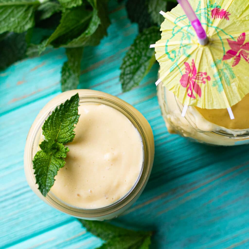 overhead view of mango smoothie, garnished with a fresh mint leaf