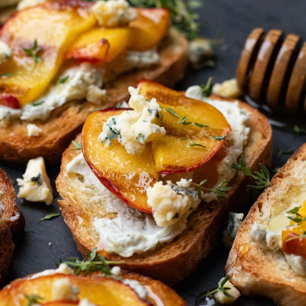 peach bruschetta topped with honey and blue cheese crumbles