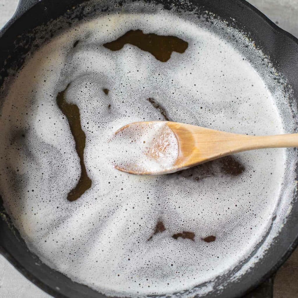 brown butter with a wooden spoon in a cast iron skillet