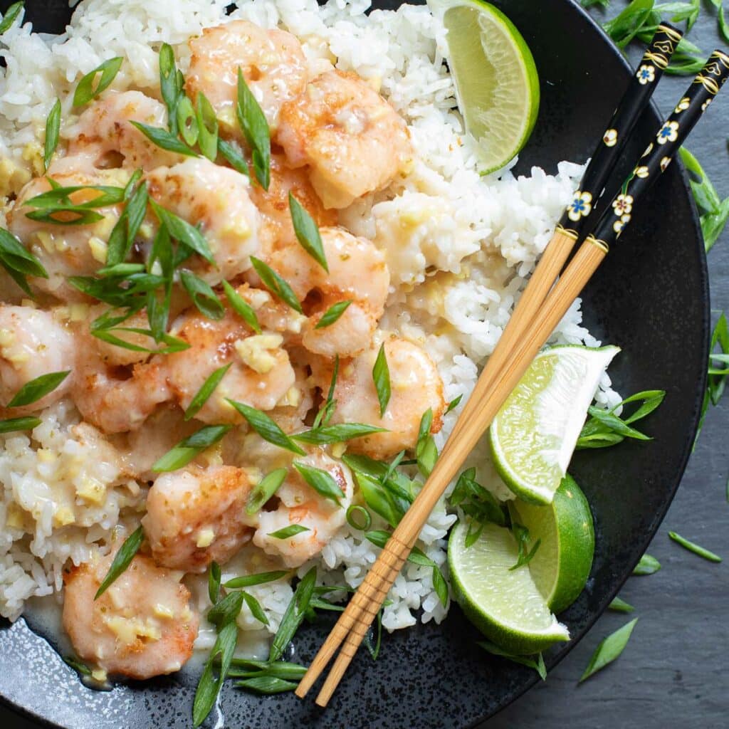 Chinese coconut shrimp on a bed of white rice on a black plate
