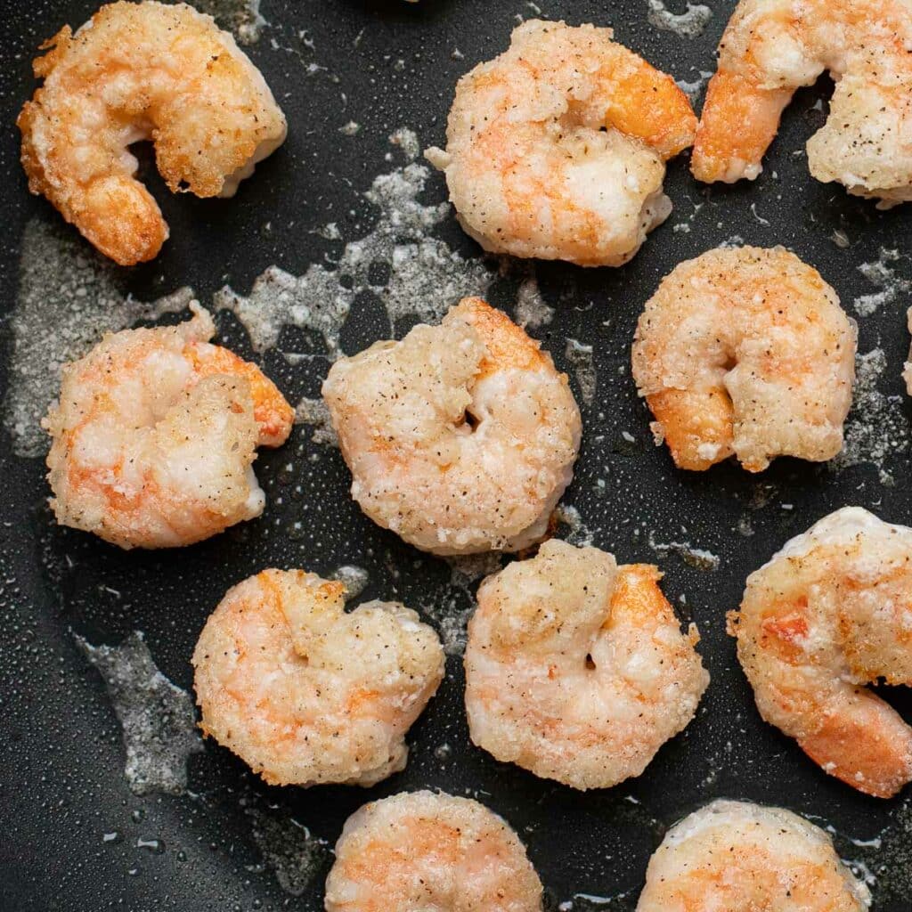 shrimp coated in cornstarch, cooking in a pan
