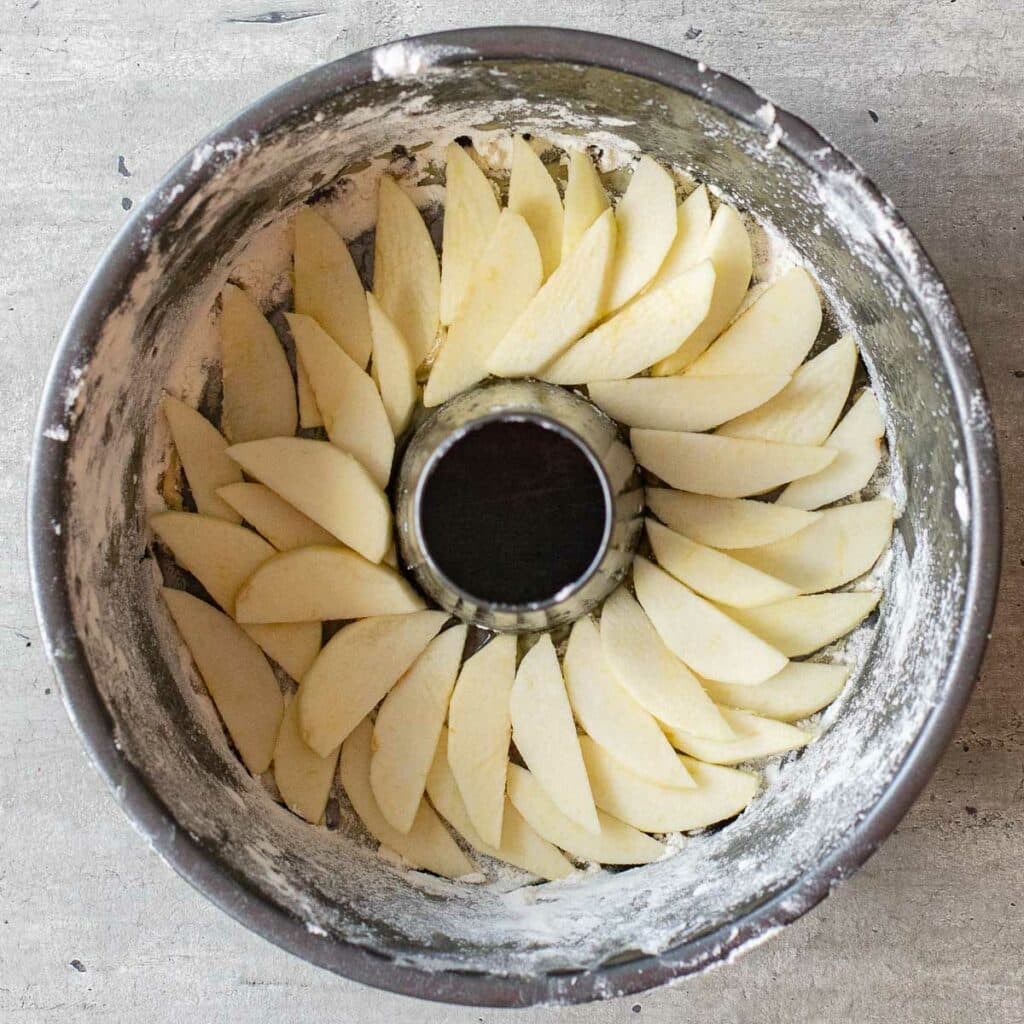 sliced apples arranged in an overlapping pattern in a tube pan
