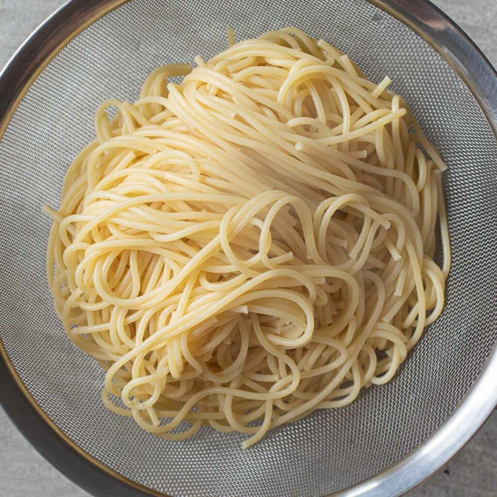 cooked pasta in a metal colander